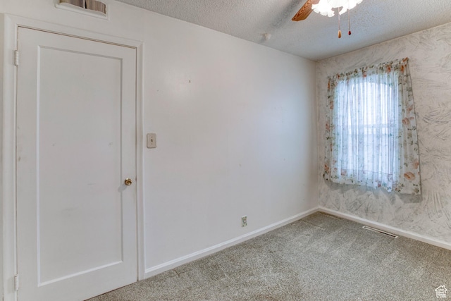 spare room with ceiling fan, carpet flooring, and a textured ceiling