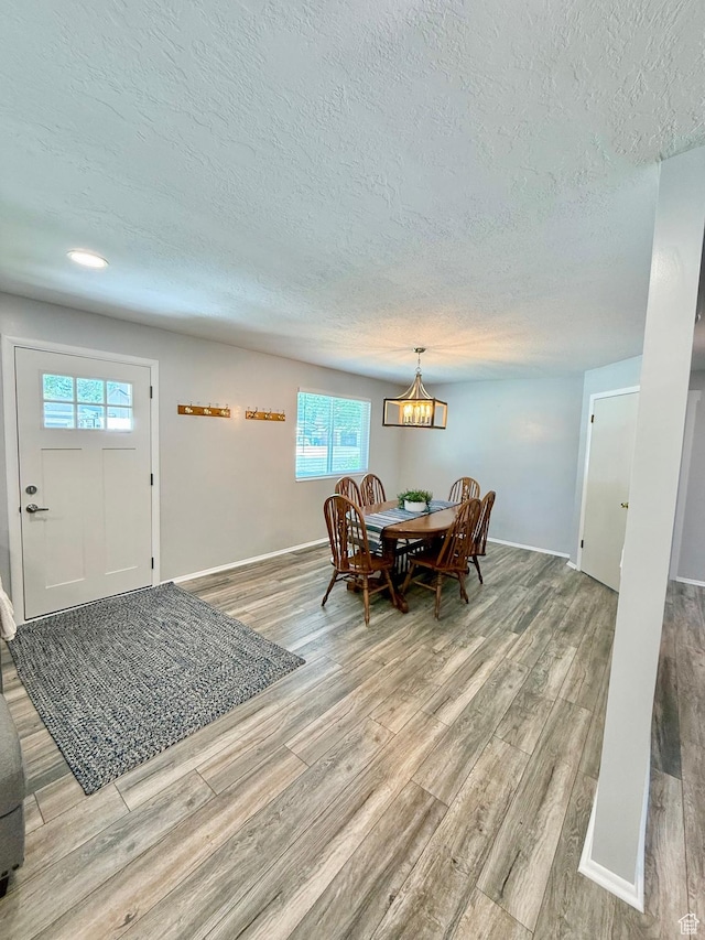1460 E Amalfi Ave, Sandy, UT 84093 - dining space with a textured ceiling, light wood finished floors, a chandelier, plenty of natural light, and baseboards