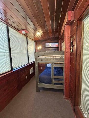 150 W Ridgeview St Unit 213, Brian Head, UT 84719 - unfurnished bedroom featuring wood ceiling, wooden walls, and carpet flooring