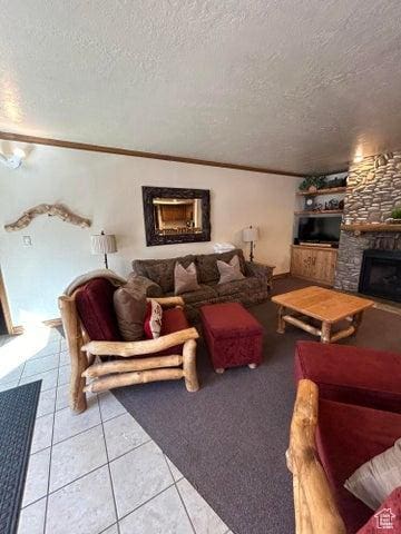 150 W Ridgeview St Unit 213, Brian Head, UT 84719 - living room featuring crown molding, tile patterned floors, a stone fireplace, and a textured ceiling