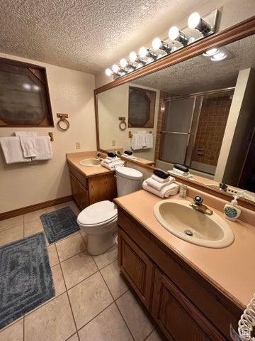 150 W Ridgeview St Unit 213, Brian Head, UT 84719 - bathroom with a shower with door, vanity, tile patterned floors, and a textured ceiling