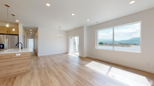 1266 S Sawmill Blvd Unit 3-303, Heber City, UT 84032 - unfurnished living room with a water and mountain view, a chandelier, sink, and light wood-type flooring