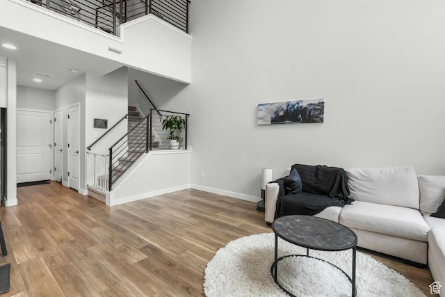 living room with a high ceiling and wood-type flooring
