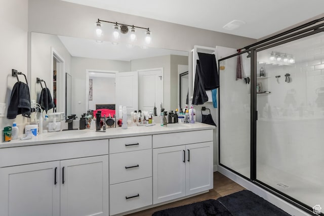 bathroom featuring hardwood / wood-style flooring, vanity, and walk in shower