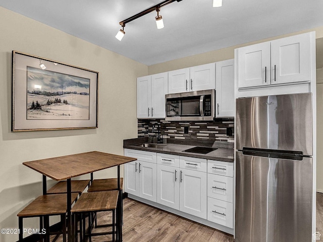 2015 Prospector Ave Unit 106, Park City, UT 84060 - kitchen featuring appliances with stainless steel finishes, sink, white cabinetry, and backsplash
