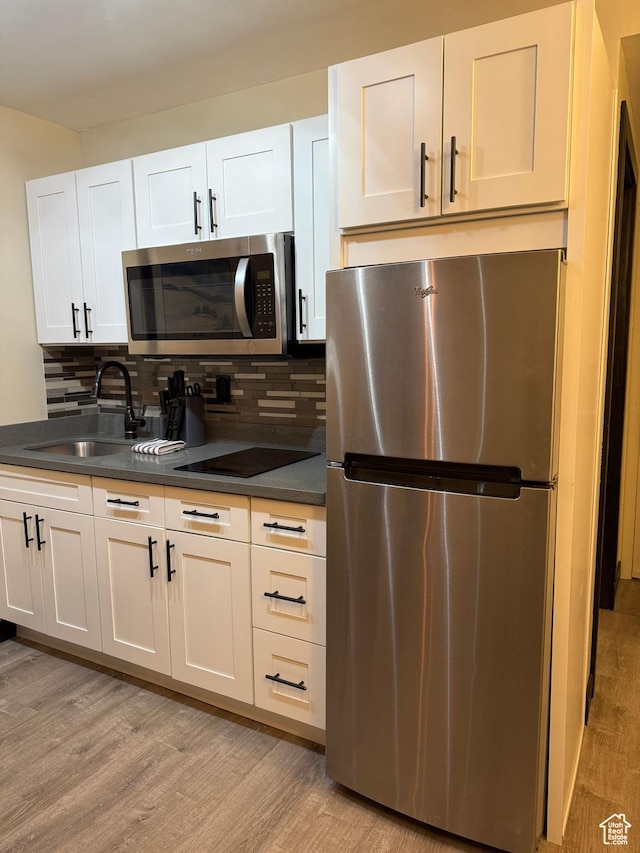 2015 Prospector Ave Unit 106, Park City, UT 84060 - kitchen featuring white cabinets, light wood-type flooring, stainless steel appliances, and sink