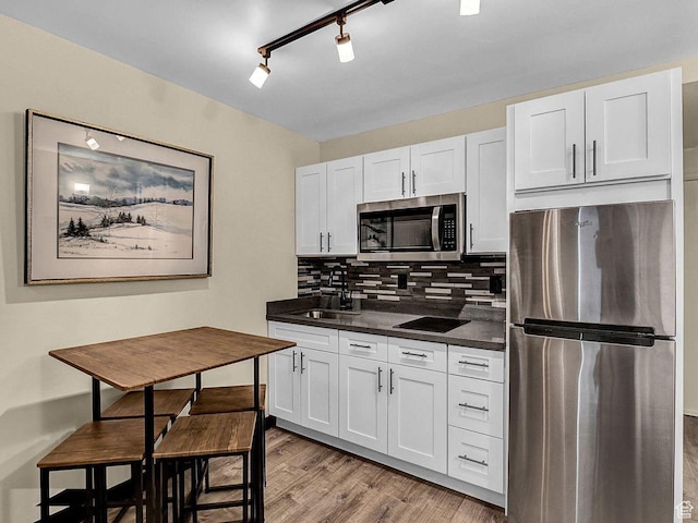 2015 Prospector Ave Unit 106, Park City, UT 84060 - kitchen with light hardwood / wood-style flooring, sink, backsplash, appliances with stainless steel finishes, and white cabinets
