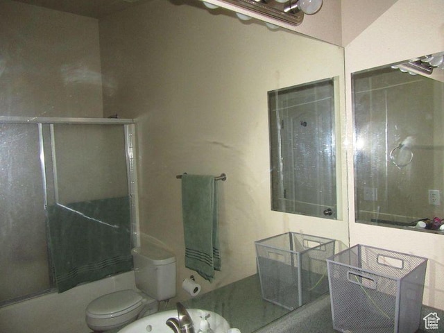 bathroom with shower / bath combination with glass door and toilet