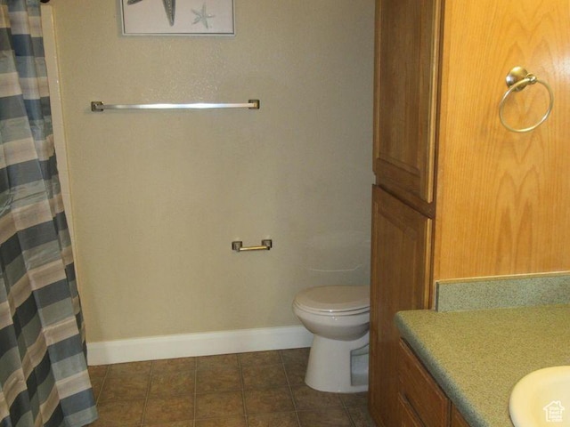 bathroom with curtained shower, vanity, toilet, and tile patterned floors