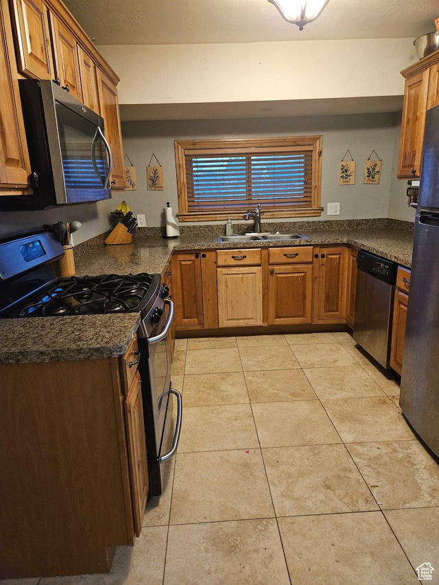 1060 E 30th S, Ogden, UT 84403 - kitchen featuring a sink, stainless steel appliances, light tile patterned flooring, and brown cabinetry