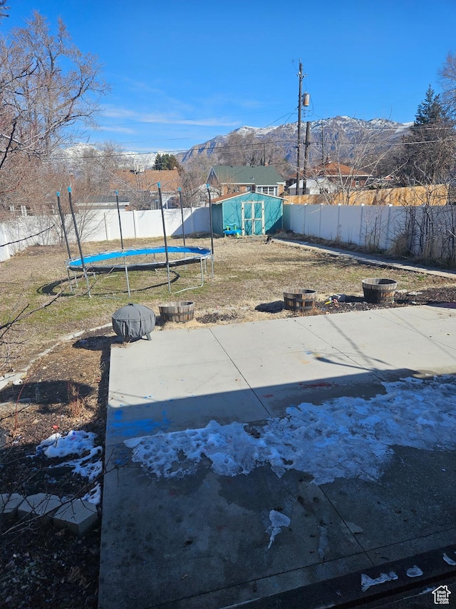 1060 E 30th S, Ogden, UT 84403 - exterior space with a shed, a fenced backyard, an outdoor structure, a trampoline, and a mountain view