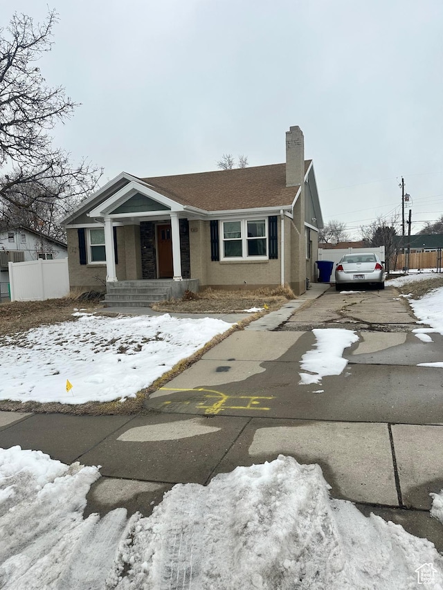 view of front of house featuring fence, driveway, and a chimney