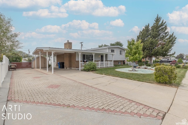 19 Sumac Way, Brigham City, UT 84302 - view of front of property featuring an attached carport, fence, a chimney, decorative driveway, and brick siding