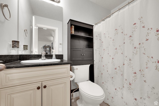 bathroom featuring toilet, vanity, and walk in shower