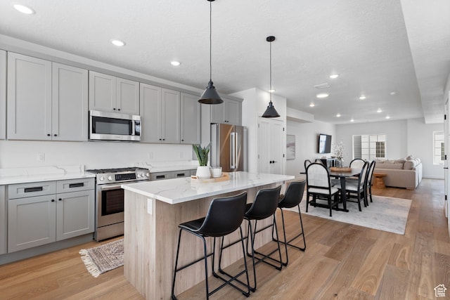 kitchen with gray cabinets, stainless steel appliances, and a center island