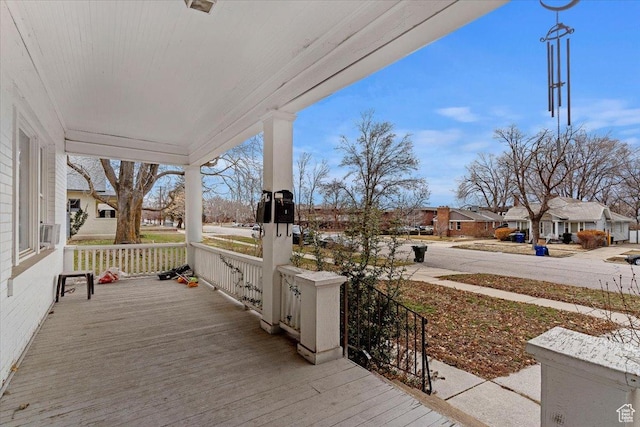 wooden terrace with covered porch and a residential view