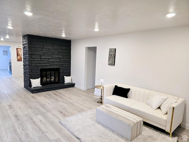 living room with a fireplace, wood finished floors, and baseboards