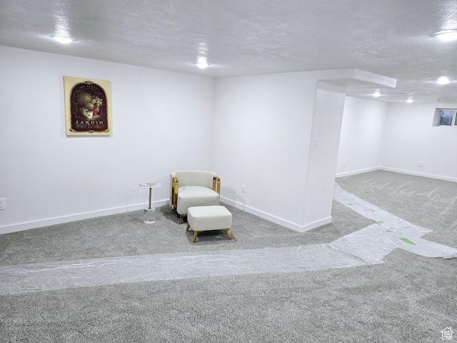 unfurnished room with a textured ceiling, carpet flooring, and baseboards