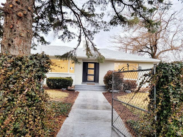 view of front of home featuring fence and brick siding