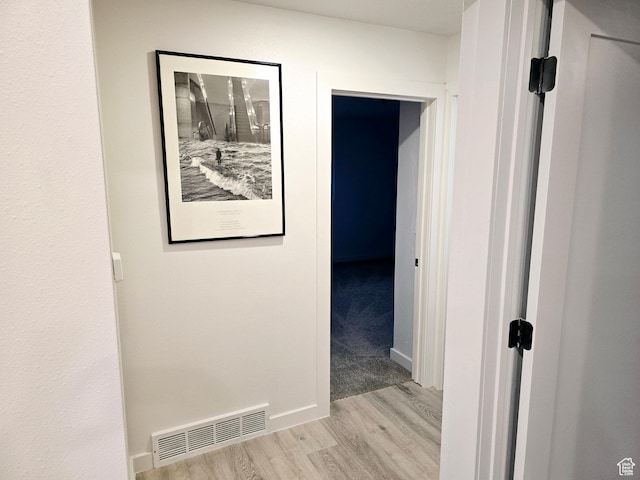 hallway featuring wood finished floors and visible vents