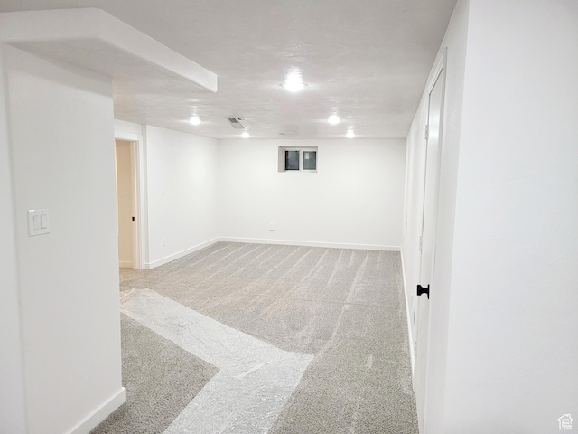 finished below grade area featuring carpet, visible vents, and baseboards
