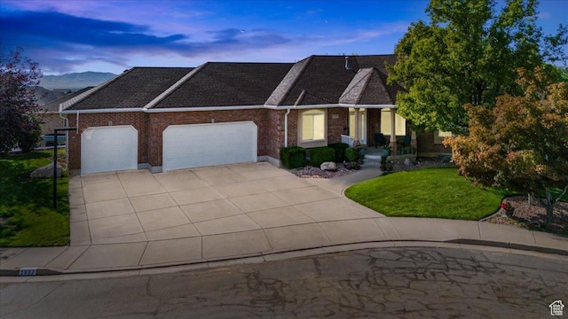 view of front of house featuring a garage, a yard, and a mountain view