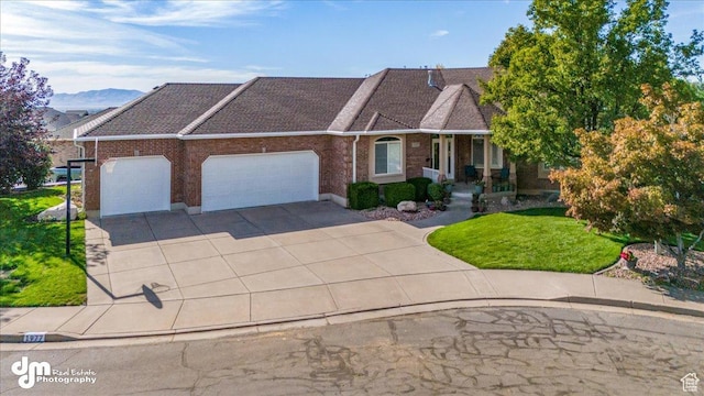 view of front of home with a mountain view, a front yard, and a garage