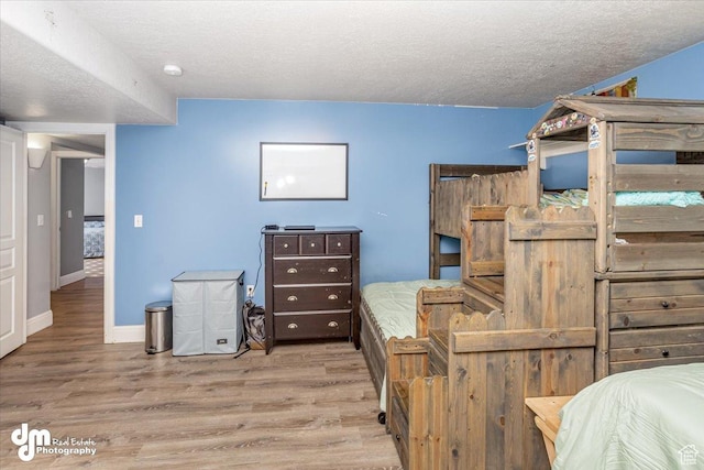 bedroom featuring light wood-type flooring and a textured ceiling