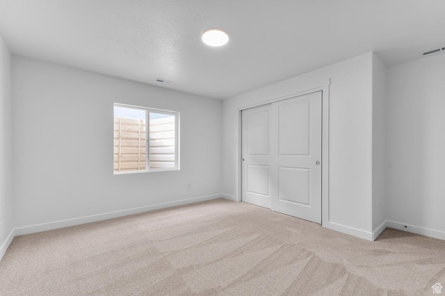 unfurnished bedroom featuring carpet floors, baseboards, and a closet
