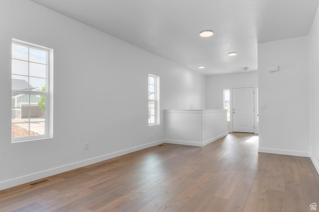 empty room featuring baseboards, light wood-style flooring, and recessed lighting