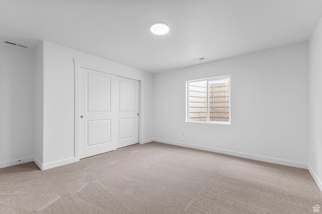 unfurnished bedroom with carpet floors, baseboards, and a closet