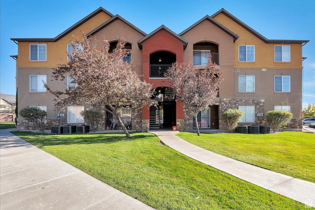 view of front of house featuring central AC unit, a front lawn, and a balcony