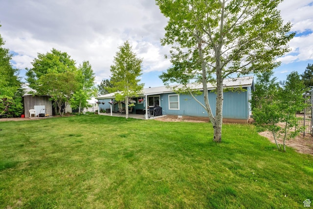 rear view of house with a lawn, a patio area, and an outdoor structure