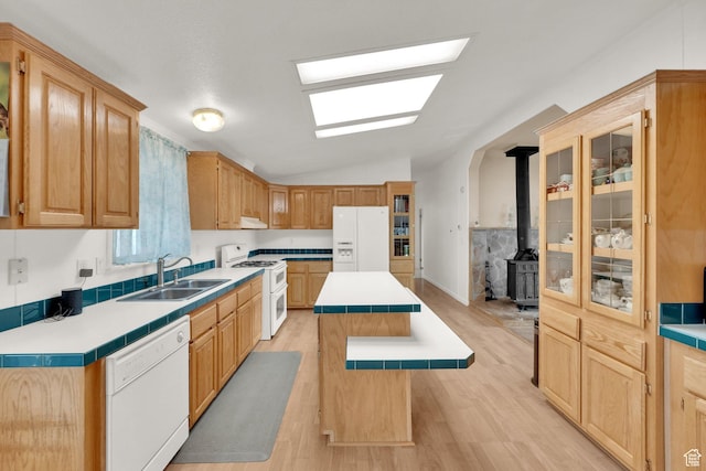 kitchen featuring white appliances, light wood finished floors, a sink, and a kitchen island