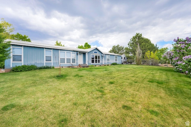 rear view of property with a lawn and board and batten siding