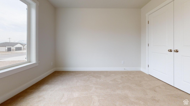 9270 N 5600 W Unit 7, Elwood, UT 84337 - unfurnished bedroom with light carpet, baseboards, and a closet
