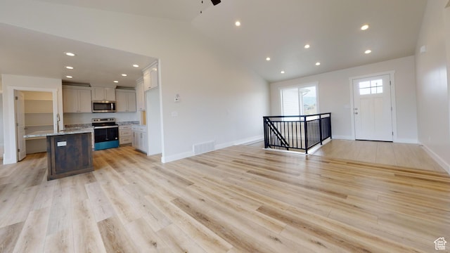 9270 N 5600 W Unit 7, Elwood, UT 84337 - kitchen with stainless steel appliances, visible vents, light wood-style floors, open floor plan, and vaulted ceiling