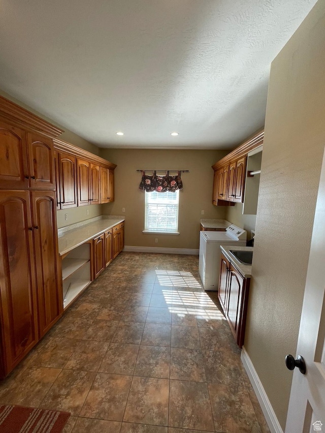 kitchen featuring washer and dryer, built in desk, and a textured ceiling