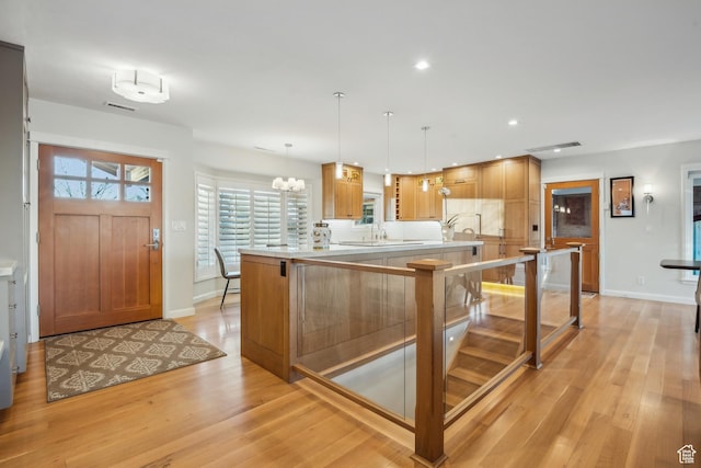5419 S Kenwood Dr E, Salt Lake City, UT 84107 - kitchen featuring light wood finished floors, light countertops, baseboards, a chandelier, and hanging light fixtures
