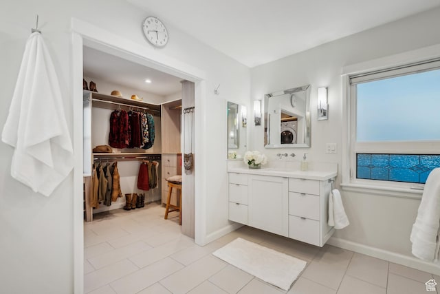 5419 S Kenwood Dr E, Salt Lake City, UT 84107 - bathroom featuring vanity, a walk in closet, tile patterned floors, and baseboards