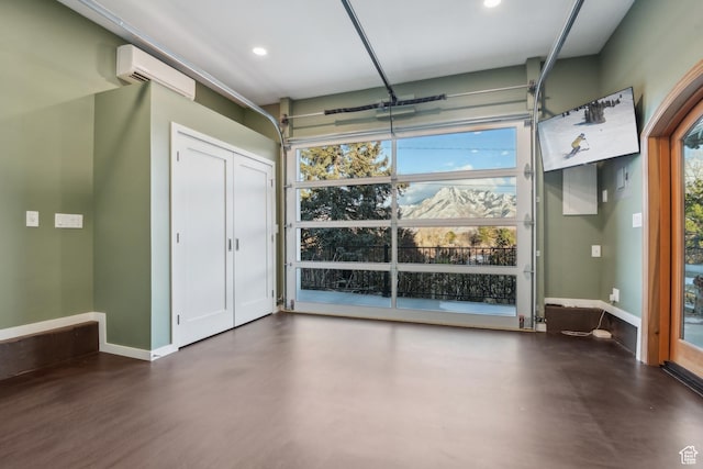 5419 S Kenwood Dr E, Salt Lake City, UT 84107 - garage featuring a wall mounted AC, baseboards, and recessed lighting