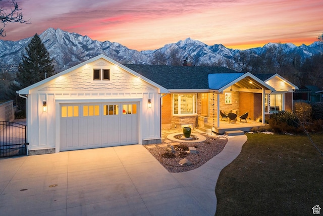 5419 S Kenwood Dr E, Salt Lake City, UT 84107 - view of front facade featuring board and batten siding, a garage, driveway, a mountain view, and a porch