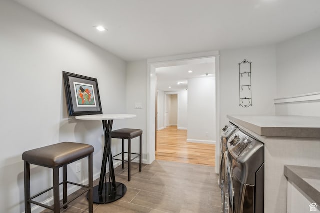 5419 S Kenwood Dr E, Salt Lake City, UT 84107 - kitchen featuring washing machine and dryer, a kitchen breakfast bar, recessed lighting, light wood-type flooring, and baseboards