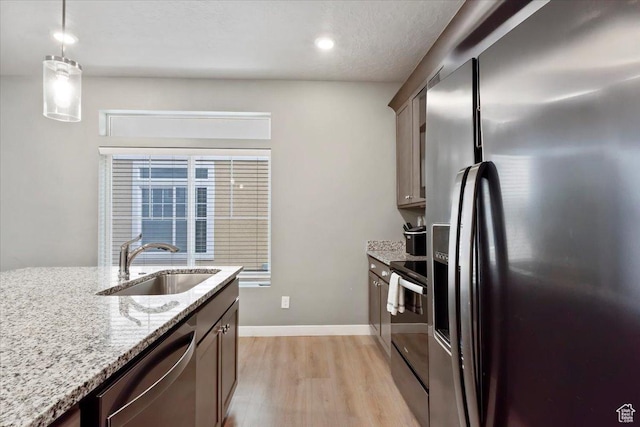 214 E Allegheny Pl S, Saratoga Springs, UT 84045 - kitchen with appliances with stainless steel finishes, a sink, light wood-type flooring, light stone counters, and pendant lighting