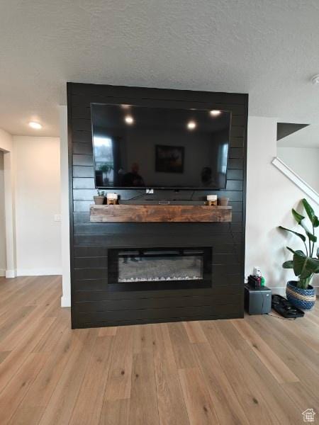 3469 S Bellrock Pl E Unit 5, South Salt Lake, UT 84115 - details with a fireplace, a textured ceiling, and hardwood / wood-style floors