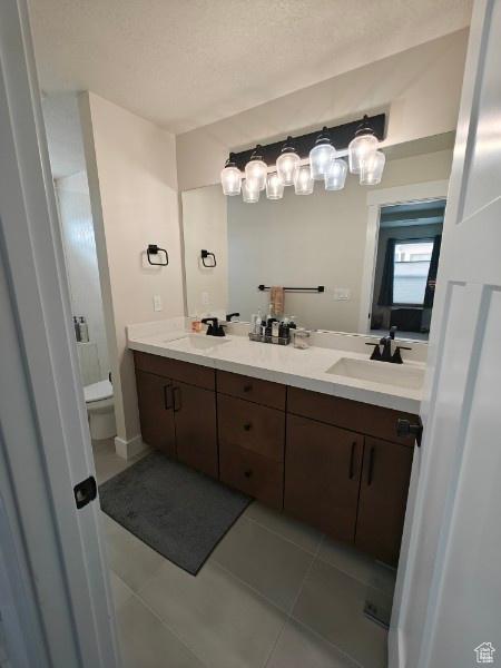 3469 S Bellrock Pl E Unit 5, South Salt Lake, UT 84115 - bathroom featuring tile patterned floors, a textured ceiling, toilet, and vanity