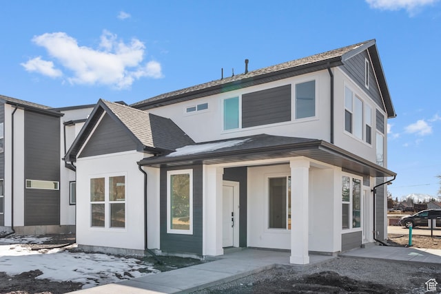 view of front of home with stucco siding and roof with shingles