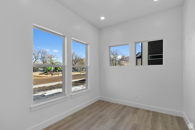 unfurnished room with recessed lighting, light wood-style floors, and baseboards