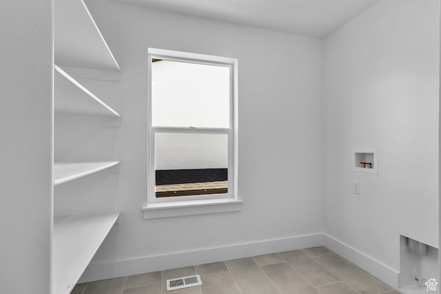 washroom featuring hookup for a washing machine, baseboards, visible vents, laundry area, and tile patterned flooring