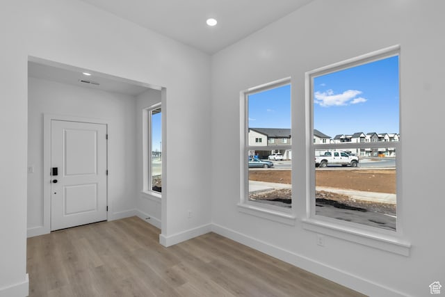 foyer featuring light wood-style flooring, recessed lighting, baseboards, and visible vents